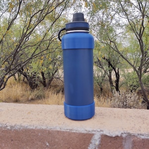 Pu&ograve; includere: Una bottiglia d'acqua in acciaio inossidabile blu con un tappo nero e una guaina in silicone blu.