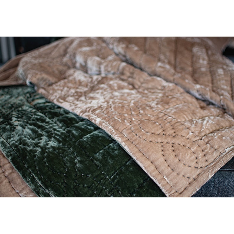 May include: Two quilted velvet throw blankets, one in a deep green color and the other in a light brown color. The blankets are folded and layered on top of each other.