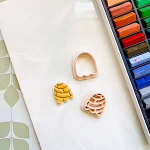 Op de afbeelding: Drie koekjesvormen in de vorm van een concha, een Mexicaans zoet brood. De vormen zijn gemaakt van roze plastic en hebben een gedetailleerd ontwerp. De concha-vorm is een populaire keuze voor bakken en decoreren.