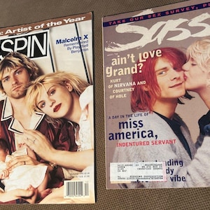 May include: Two vintage music and lifestyle magazines. The left magazine is Spin, featuring Kurt Cobain, Courtney Love, and a baby on the cover with text including Nirvana: Artist of the Year. The right magazine is Sassy, featuring Kurt Cobain and Courtney Love with the text Sassy and ain't Love Grand?