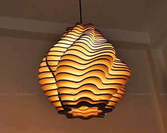 May include: A modern, sculptural pendant light fixture. The light has a layered, wave-like design with alternating dark and light wooden strips. The fixture is suspended from a black cord and emits a warm, inviting glow.