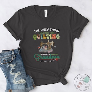 May include: A dark gray t-shirt with a colorful sewing machine graphic and the text "The only thing I love more than quilting is being a Grandma".