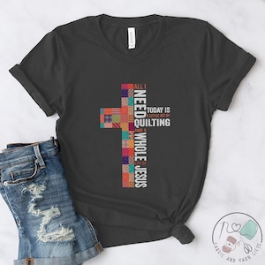 May include: A dark gray t-shirt with a patchwork cross design and the text "All I Need Whole Jesus Today is a little bit of Quilting and a lot of" printed on it.