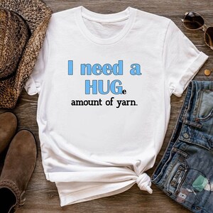 May include: White t-shirt with the text "I need a HUGE amount of yarn." in blue lettering.