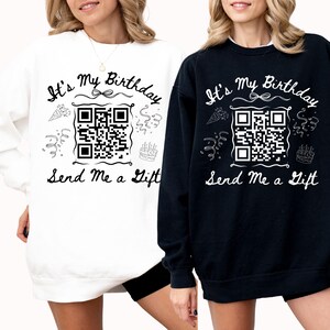 May include: Two black and white sweatshirts with the text "It's My Birthday Send Me a Gift" and a QR code. The sweatshirts are being worn by two people wearing black shorts.