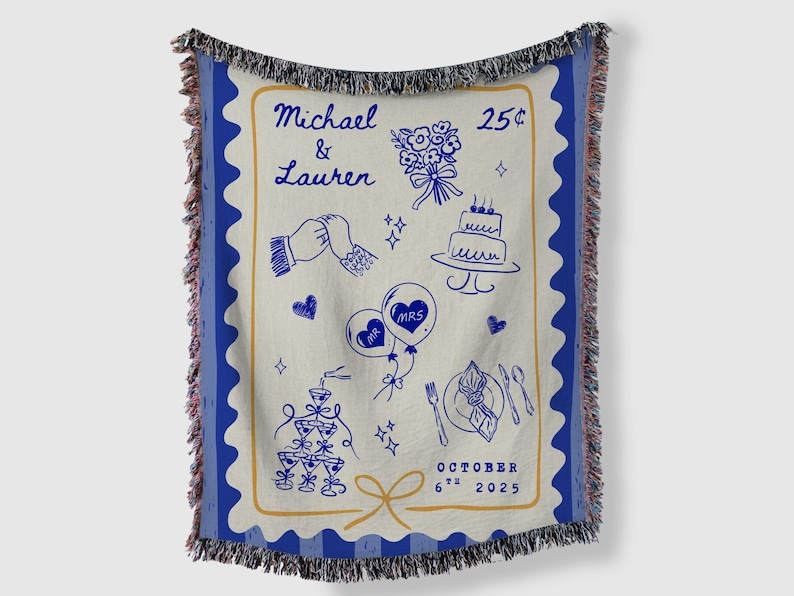 May include: A woven throw blanket with a blue border and fringe. The cream-coloured centre features blue line art of wedding-themed illustrations, including a cake, flowers, and balloons. Text includes names and a date.