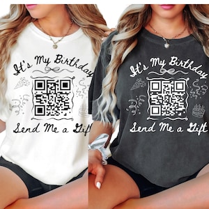 May include: Two women wearing white and gray t-shirts with the text "It's My Birthday Send Me a Gift" and a black and white QR code. The shirts have a white and black graphic design with confetti and a birthday cake.