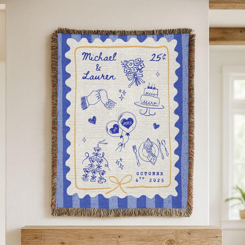 May include: A blue and white woven throw blanket with a stamp-like design. It features wedding-themed illustrations and the names "Michael & Lauren." The date "October 6th 2025" is also displayed on the blanket.