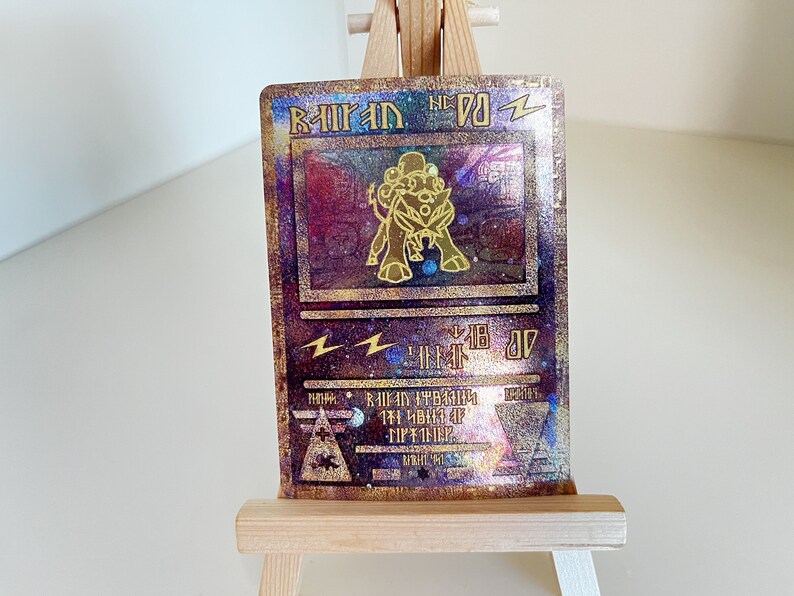 May include: A gold and purple holographic Pokemon card featuring a golden Raichu with the text "Raichu No. 26 Zz", "Lightning" symbol, and "Level 18 07" in the background.