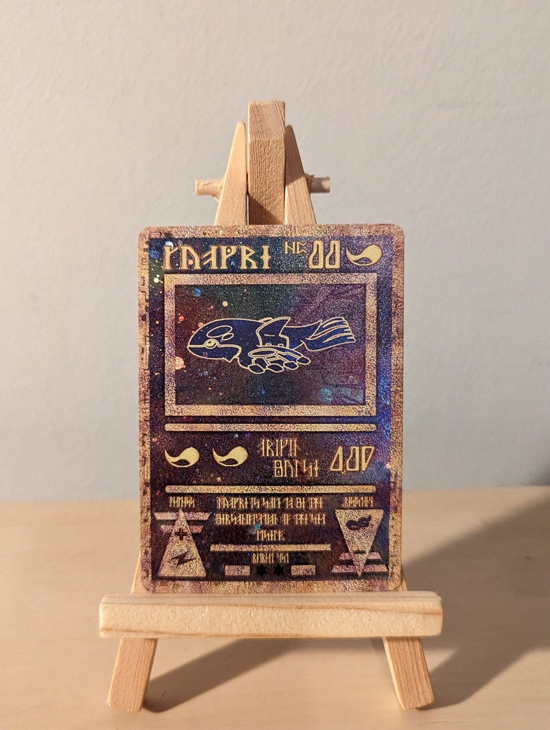 May include: A holographic trading card with a blue and purple background. The card features a black and white illustration of a creature with wings and a text box that reads "MAPPY NE 00".