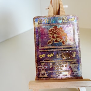 May include: A holographic Pokemon card featuring a gold and red illustration of a Pokemon character. The card number is 70 and the card name is "Flareon".