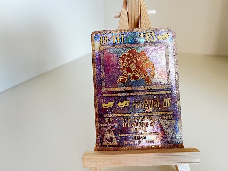 May include: A holographic Pokemon card featuring a gold and red illustration of a Pokemon character. The card number is 70 and the card name is "Flareon".