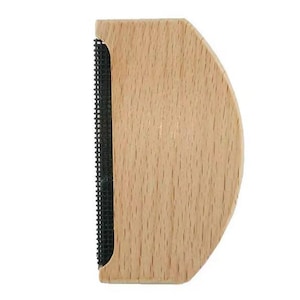 Könnte beinhalten: Ein hölzerner Fusselrasierer mit einer schwarzen Stoffklinge. Die Klinge ist so konzipiert, dass sie Fussel, Flusen und Knötchen von Kleidung entfernt.