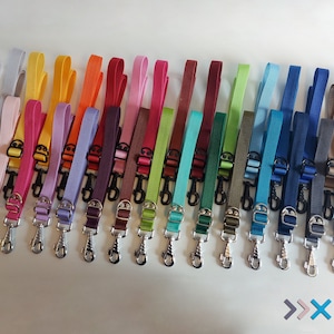 Pode incluir: Uma variedade de 20 coleiras para cães coloridas com clipes prateados. As coleiras são feitas de um material tecido durável e estão disponíveis em uma gama de cores, incluindo vermelho, azul, verde, amarelo e roxo.