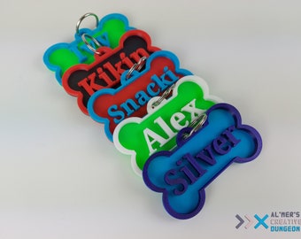 Pode incluir: Cinco etiquetas para cães em forma de osso de cores diferentes com nomes personalizados: Ivy, Kilkin, Snacki, Alex e Silver. As etiquetas são de plástico e têm um anel de metal prateado.