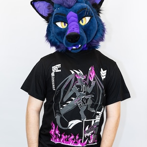 May include: A person wearing a blue and purple wolf fursuit head and a black t-shirt. The t-shirt features a graphic of a dragon with flames and the text "AL'HER'S CREATIVE DUNGEON". The fursuit head has yellow eyes.
