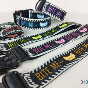 May include: A set of five black and white striped dog collars with the text "Bite Me" in various colors. The collars are made of a durable, comfortable material and are perfect for dogs of all sizes.