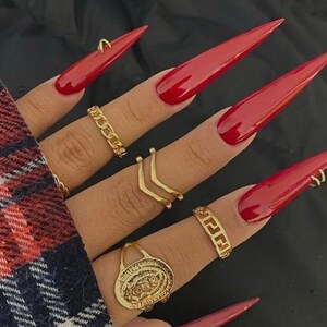 Red med/long stiletto nails with piercings gold