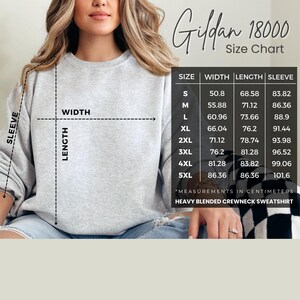 May include: A light gray crewneck sweatshirt with a size chart. The chart displays measurements in centimeters for width, length, and sleeve length, ranging from size S to 5XL. The text "Gildan 18000" is visible.