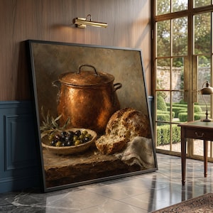 May include: A framed still life painting depicting a large, round, metallic copper pot with a lid, a shallow bowl filled with dark and green olives, and a crusty loaf of bread resting on a wooden surface, all rendered in warm, earthy tones.