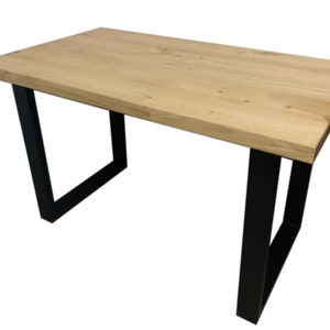 May include: A wooden table with a natural finish and black metal legs. The table has a rectangular top and a simple design.