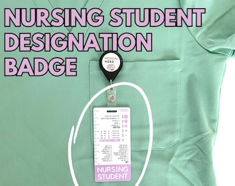 May include: A green scrub top with a pocket on the left side. A badge holder with a badge that says "Nursing Student" is attached to the pocket. The badge holder also has a small round badge that says "Medical Nerd".