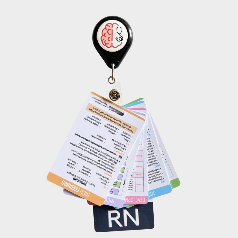 May include: A black retractable badge holder with a brain and stethoscope graphic. The holder is attached to a set of colorful cards with the text "NICU FEEDINGS", "NEURODEVELOPMENTAL", "DEVELOPMENT", and "RN".