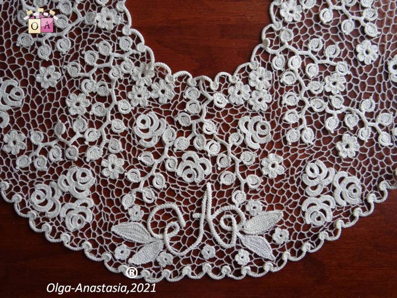 Peut inclure: Collier en dentelle crochet&eacute;e blanche avec un motif floral et un d&eacute;licat motif de roses et de feuilles. Le collier a un bord festonn&eacute; et une petite inscription qui dit "Olga-Anastasia, 2021".