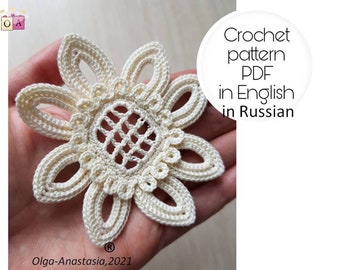 May include: A crocheted flower motif in cream, with a detailed center and six petals. The pattern is available in both English and Russian.