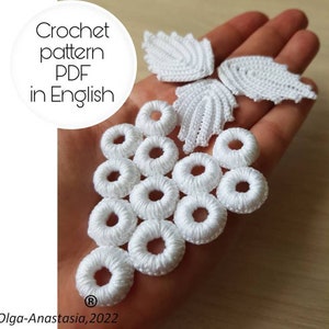 Pode incluir: Motivos de flores brancas de crochê e um conjunto de anéis de crochê. A imagem inclui o texto "Crochet pattern PDF in English" e "Olga-Anastasia, 2022".