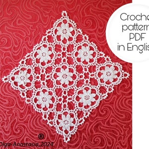 Könnte beinhalten: Weiße Häkeldeckchen mit quadratischer Form und floralem Muster. Das Deckchen liegt auf einem roten Hintergrund. Häkelmuster PDF in Englisch.