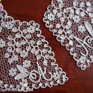 Peut inclure: Deux cols en dentelle crochet&eacute;e blanche avec des motifs floraux. Les cols sont pos&eacute;s sur une surface en bois brun. Le texte "Olga-Anastasia, 2021" est visible en bas de l'image.