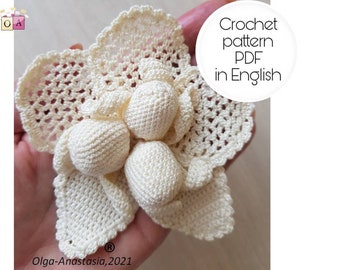 Puede incluir: Una flor de ganchillo con un grupo de pequeñas bolas blancas de ganchillo en el centro. La flor es blanca y tiene un delicado patrón de encaje. El texto "Crochet pattern PDF in English" es visible en la imagen.