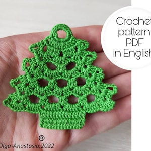 Pode incluir: Um enfeite de árvore de Natal verde em crochê com um laço no topo. Padrão de crochê PDF em inglês.