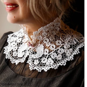 Puede incluir: Un collar de encaje blanco tejido a crochet con un delicado patr&oacute;n floral. El collar se lleva sobre una blusa negra.