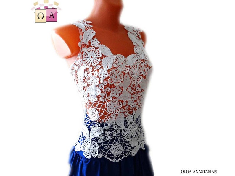 May include: White crochet top with a delicate floral pattern. The top is sleeveless and has a scoop neck. It is made of a lightweight, breathable fabric and is perfect for layering.