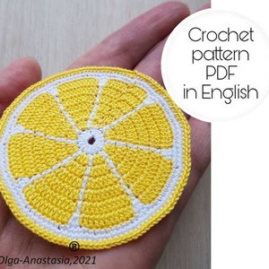 Könnte beinhalten: Häkeluntersetzer in Form einer Zitronenscheibe in Gelb und Weiß. Der Untersetzer hat die Form einer Zitronenscheibe mit einer weißen Mitte und gelben Außenkanten. Der Text "Crochet pattern PDF in English" ist im Bild sichtbar.