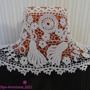 Puede incluir: Collar blanco de ganchillo con un delicado dise&ntilde;o floral y dos borlas. El collar se muestra sobre un fondo negro.