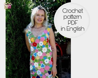 May include: A woman wearing a colorful crochet dress with floral patterns. The dress is sleeveless and has a V-neckline. The woman is standing in front of a green bush. The text "Crochet pattern PDF in English" is visible in the image.