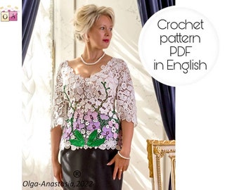 May include: A white crochet top with a floral design featuring purple and green accents. The top has a V-neck and three-quarter sleeves. The text "Crochet pattern PDF in English" is visible in the image. The text "Olga-Anastasia, 2022" is also visible in the image.