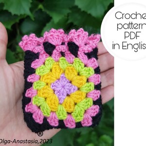 May include: A crochet pattern PDF in English for a colorful granny square with pink, yellow, green, and purple yarn. The square is black with a pink border.