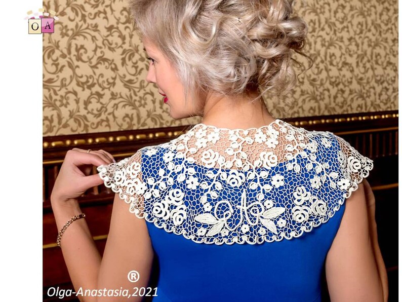 Peut inclure: Un col en crochet blanc avec un motif floral. Le col est port&eacute; sur une robe bleue. Le texte "Olga-Anastasia, 2021" est visible en bas de l'image.