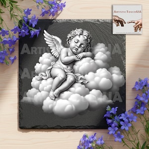 May include: A grayscale slate coaster featuring a sleeping cherub resting on fluffy clouds. The cherub has detailed wings and is draped in a cloth. The coaster has the text "ARTISTIC TOUCH UA" and a logo.
