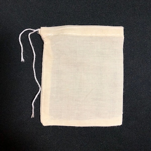 May include: A small, white, drawstring muslin bag with a white string.