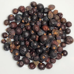 May include: A pile of dried juniper berries, a dark brown color with some lighter brown spots.