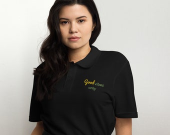 May include: A black polo shirt with short sleeves and a yellow and green embroidered design that says "Good vibes only".