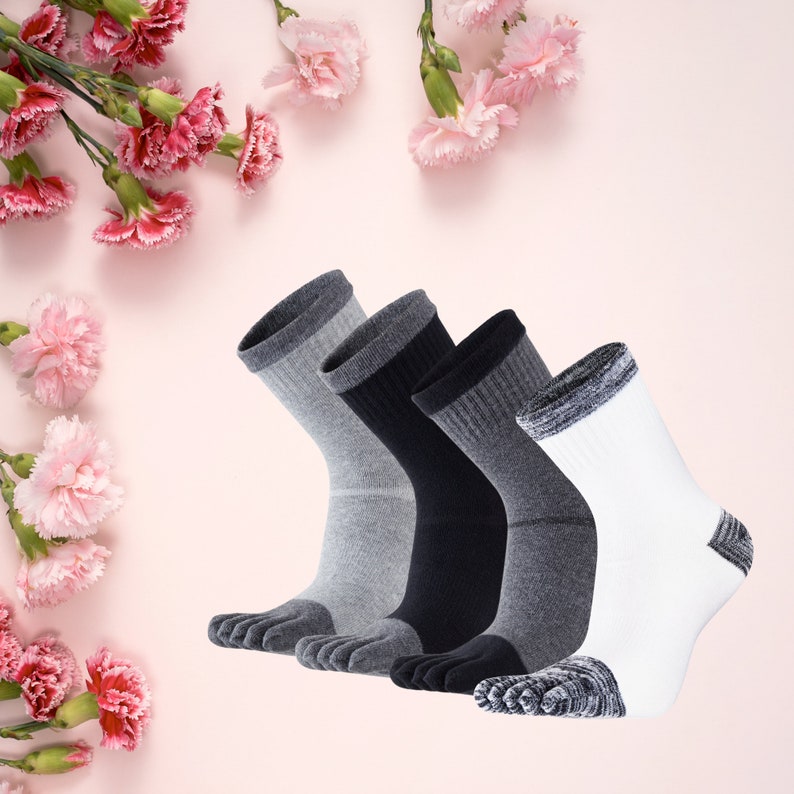 May include: A set of five toe socks in various colors: light gray, dark gray, black, and white. The socks have reinforced heels and toes. The background is a soft pink with pink flowers.