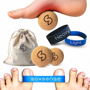 May include: Two cork massage balls with a logo, a small canvas bag with a logo, and two blue rubber bands with the words "Heavy" and "Light" printed on them. The cork balls are used for foot massage.