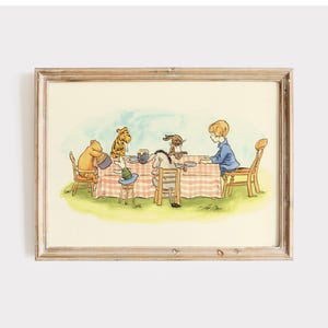 May include: A framed illustration depicting a gathering of Winnie the Pooh characters around a table. The scene includes a red and white checked tablecloth, wooden chairs, and a light blue sky. The artwork has a vintage, storybook style.