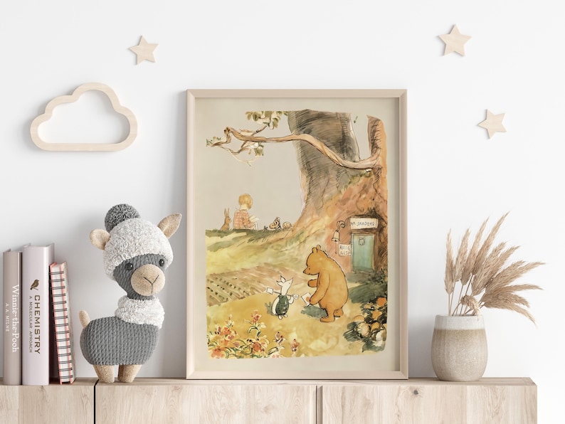 May include: A vintage illustration of Winnie the Pooh and Piglet standing in front of a tree house with the words "The Hundred Acre Wood" above the door. The illustration is in a light brown frame.